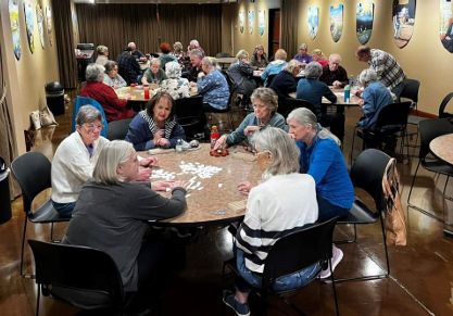 Seniors playing a game together in a community room.